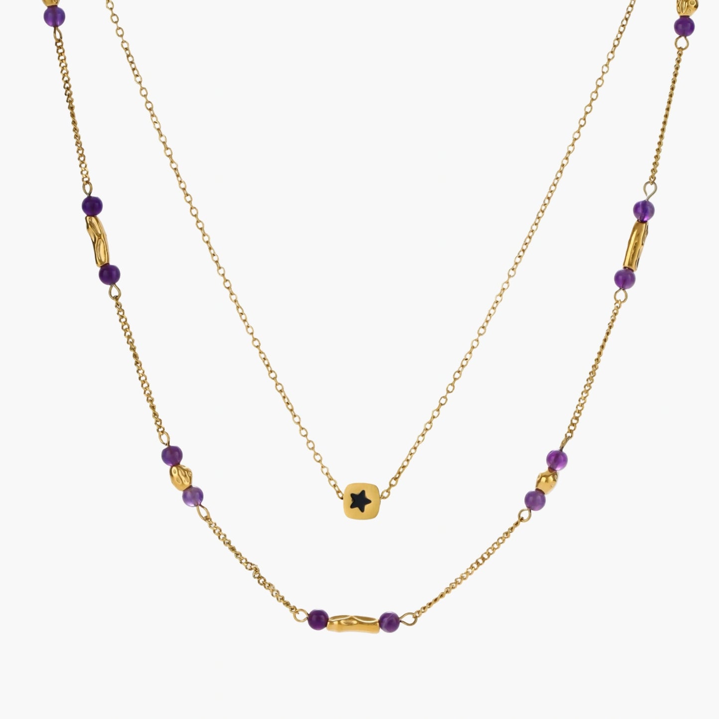 Two layered gold-tone necklaces with purple stone beads and star pendant against cream background.