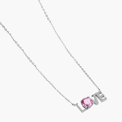 Sterling silver LOVE necklace with pink moissanite stone replacing the O, featuring crystal-set letters on delicate chain.