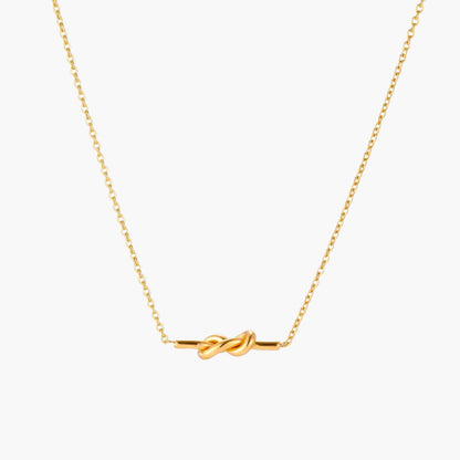 Dainty 18K gold plated necklace with infinity knot pendant on delicate chain against white background