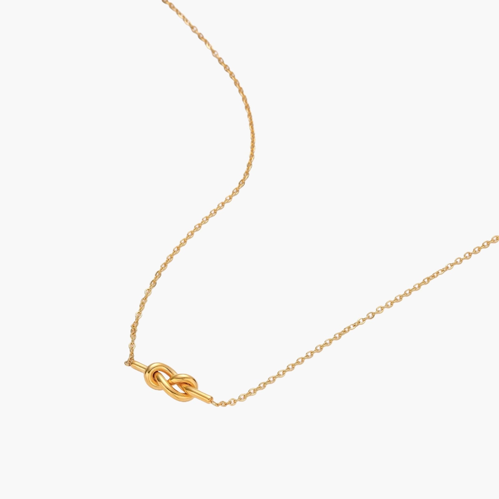 Dainty 18K gold plated necklace with infinity knot pendant on delicate chain against white background